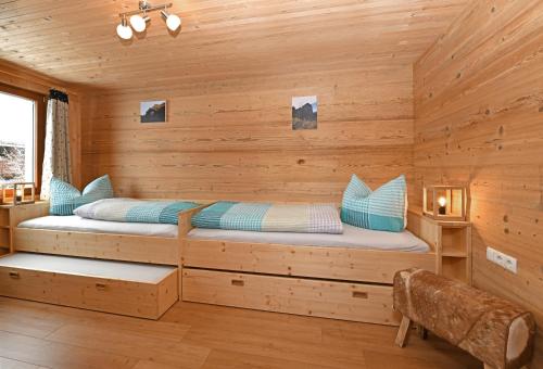 a log cabin bedroom with two beds in it at Schmiedlarhof in Au im Bregenzerwald