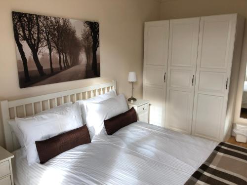 ein Schlafzimmer mit einem großen weißen Bett mit weißen Kissen in der Unterkunft Oakbank - Comfort in the Glens! in Edzell