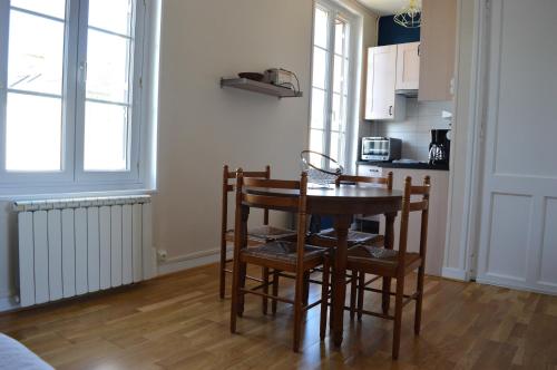 uma cozinha com mesa e cadeiras num quarto em Appart à 2 pas de la plage - Centre d'Asnelles em Asnelles