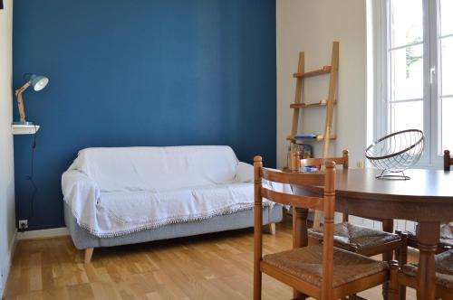 a room with a table and a blue wall at Appart à 2 pas de la plage - Centre d'Asnelles in Asnelles
