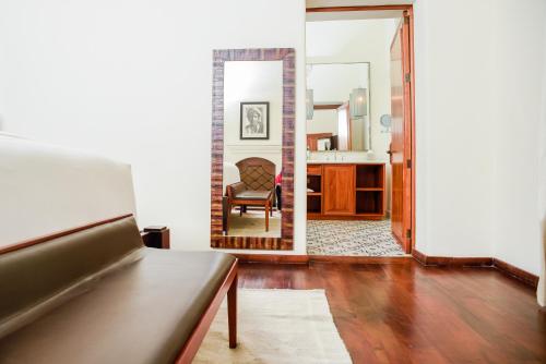 a living room with a chair and a mirror at Hotel Casa Blanca 7 in San Miguel de Allende