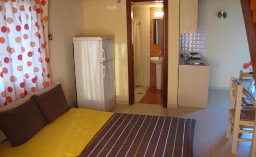a room with a bed and a kitchen with a refrigerator at Koromilia Villa in Neo Klima