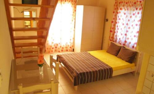 a small bedroom with a bed and a window at Koromilia Villa in Neo Klima