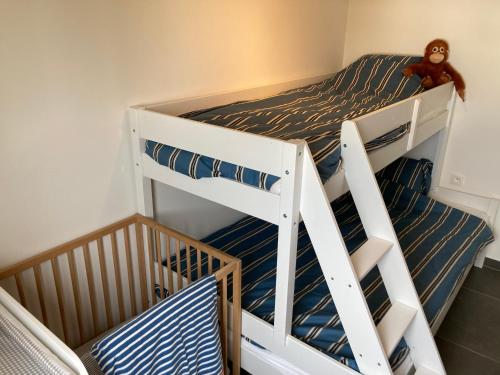 a bunk bed with a teddy bear sitting on top at Maison Coxyde in Koksijde