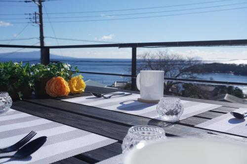 a dining table with a view of the ocean at Luana Marue in Ito