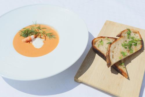 a white plate with a sandwich and a bowl of soup at Fredensborgs Herrgård in Vimmerby
