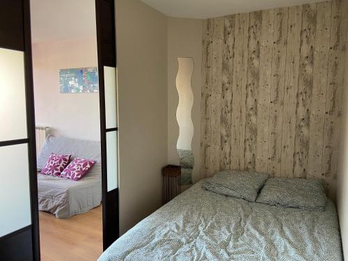 a small bedroom with a bed and a mirror at Appartement Circé - Montpellier Nord-Hopitaux-Facultés in Montpellier