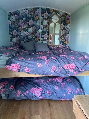 a bed in a bedroom with a flowery wall at Bryn Parc in Llandysul