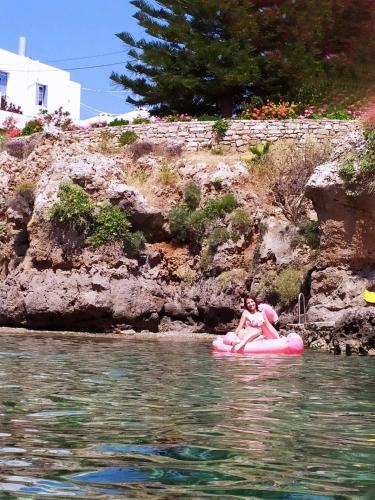 two people riding on a pink raft in the water at DonQuihotel Chalet in Karvounádhes