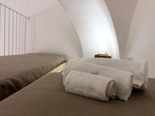 two beds in a room with a lamp on a table at Casa Toti in Matino