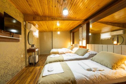 three beds in a room with wooden ceilings at Candy Hotel in Istanbul