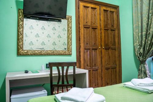 a room with a bed and a table and a mirror at Hotel Ferrarese in Rome
