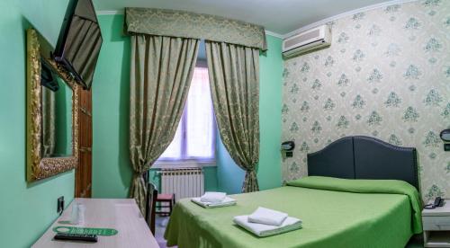 Dormitorio verde con 2 camas y ventana en Hotel Ferrarese, en Roma