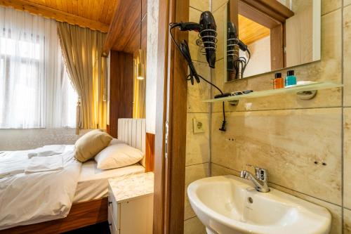 a bathroom with a sink and a bed in a room at Candy Hotel in Istanbul