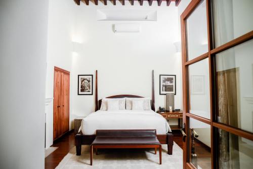 a bedroom with a white bed and a table at Hotel Casa Blanca 7 in San Miguel de Allende