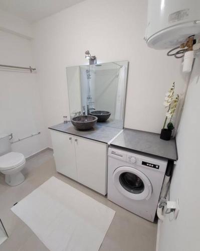 a bathroom with a washing machine and a sink at Hello Guyane, Suite Collection (5), 5 étoiles. in Cayenne
