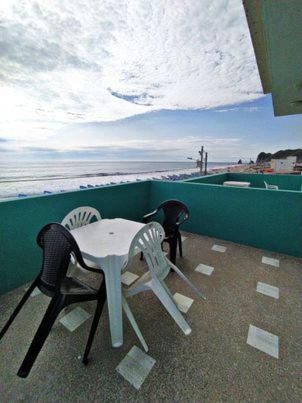 two chairs and a table on a balcony overlooking the beach at The Lookout Beach Hotel in San Lorenzo