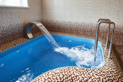 a tub with a water fountain in a bathroom at Sytiy Putnik Hotel in Smolnitsa