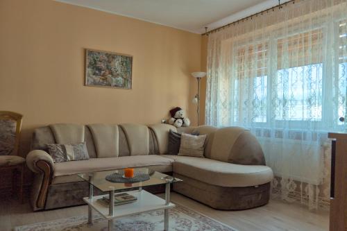 sala de estar con sofá y ventana en Estate I Apartamentai en Birštonas