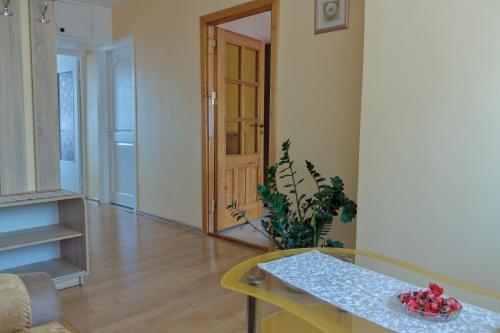 salon ze stołem i rośliną w obiekcie Estate I Apartamentai w mieście Birsztany