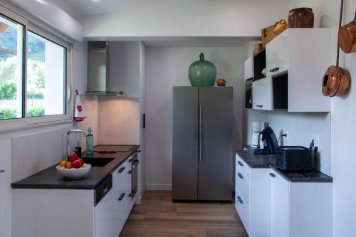 a kitchen with a refrigerator and a bowl of fruit on the counter at Villa Art Natura in Juzet-de-Luchon