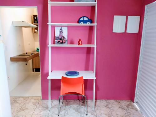 a pink room with a white shelf and a stool at 10 Studios in Sao Paulo