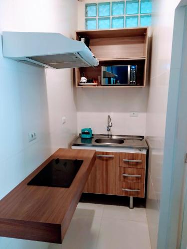 a small kitchen with a sink and a microwave at 10 Studios in Sao Paulo