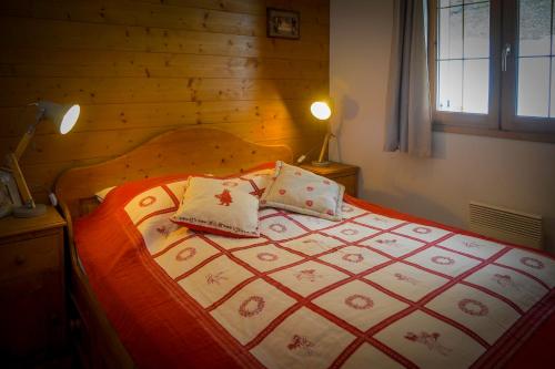 a bed with two pillows on it in a bedroom at T2 Meublé Tourisme 3 etoiles, pied des pistes-parking privé avec balcon et superbe vue in Les Deux Alpes