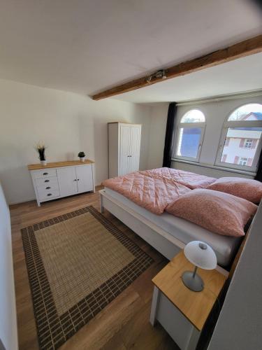 um quarto com uma cama grande e 2 janelas em Ferienwohnung Sonnenhaus em Wonsees