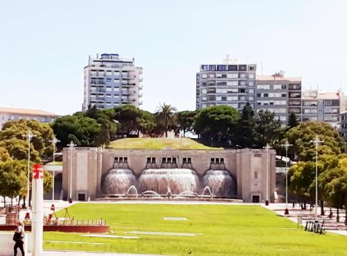 a building with a fountain in the middle of a park at Mini Hostel in Lisbon in Lisbon