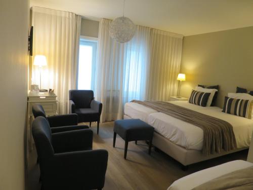 a hotel room with a bed and a chair at Hotel Alegria in Bruges