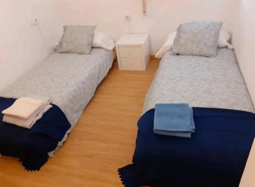 2 Einzelbetten in einem Zimmer mit Holzböden in der Unterkunft Praia da Borna 1ºA in Moaña