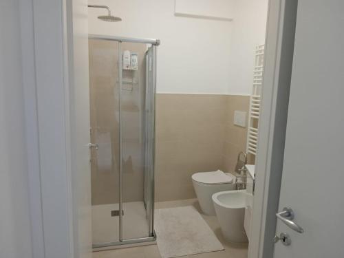 uma casa de banho com uma cabina de duche em vidro e um WC. em Appartamento Pleiadi em Finale Ligure