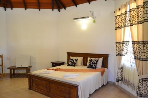 A bed or beds in a room at Nirukthie Beach Resort & Restaurant