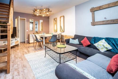 a living room with a couch and a table at Duplex cosy et contemporain avec parking privé in Amiens