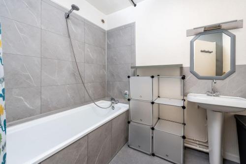 ein Badezimmer mit Waschbecken, Badewanne und Spiegel in der Unterkunft Duplex cosy et contemporain avec parking privé in Amiens