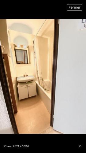 une petite salle de bain avec un lavabo et un miroir dans l'établissement Studio Sète vue sur l’étang de Thau, à Sète