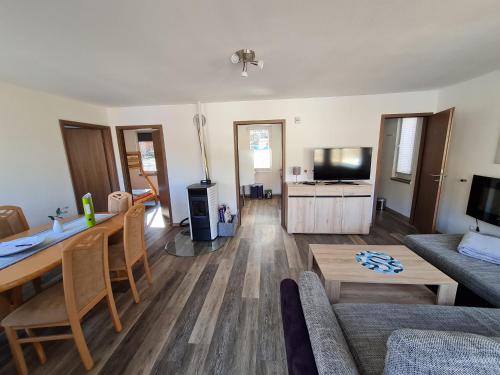 a living room with a table and a couch at Ferienhaus am Badesee Schönsee Bungalow 12 in Urnshausen