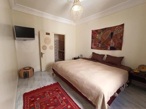 Schlafzimmer mit einem Bett und einem Flachbild-TV in der Unterkunft Happy Surf Hostel in Taghazout