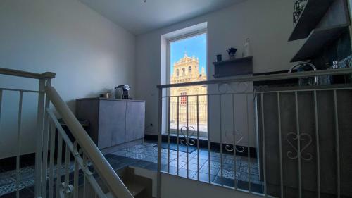 a room with a balcony with a view of a building at Palazzo Framì in Acireale
