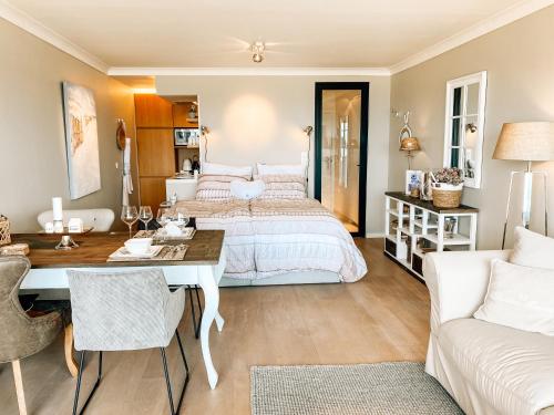 een slaapkamer met een bed, een bureau en een bank bij la MERéMOI - Studio with balcony and sea vie in Oostende