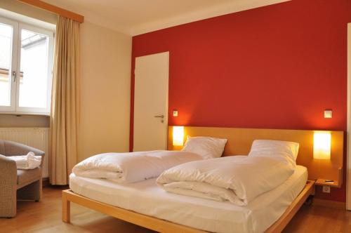 a bedroom with two beds and a red wall at Villa Welcome in Mondorf-les-Bains