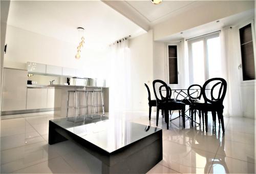 a dining room and kitchen with a table and chairs at High-End Apartment, Hyper Center, Near The Beaches in Nice