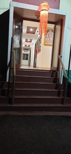 una escalera que conduce a un edificio con una lámpara de araña en HOTEL S K PALACE, en Mahabaleshwar