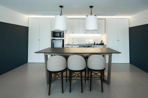 a kitchen with a table and some white chairs at Marina House MUAYTHAI Ta-iad Phuket in Chalong 