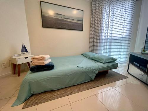 Dormitorio con cama, escritorio y TV en Beachfront Flat, en Florianópolis