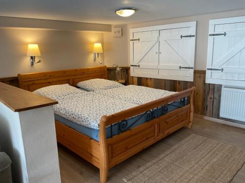 um quarto com uma cama de madeira e 2 janelas em Apartment,Wohnung & Zimmer 'Am Waldfreibad' em Much