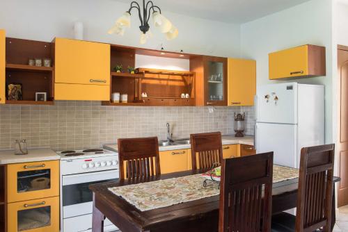 a kitchen with yellow cabinets and a table with chairs at Psi·Theros in Kriopigi