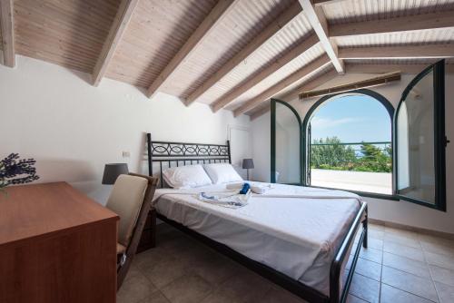 a bedroom with a bed and a large window at Psi·Theros in Kriopigi