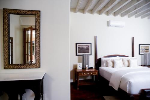 a bedroom with a bed and a mirror at Hotel Casa Blanca 7 in San Miguel de Allende
